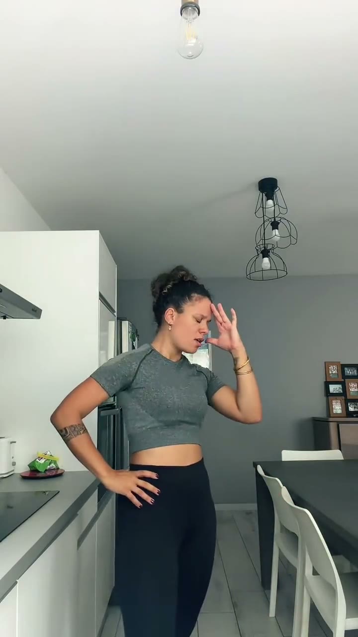 A frame from a Bad Times trend video: a woman in a kitchen with her hand on her forehead
